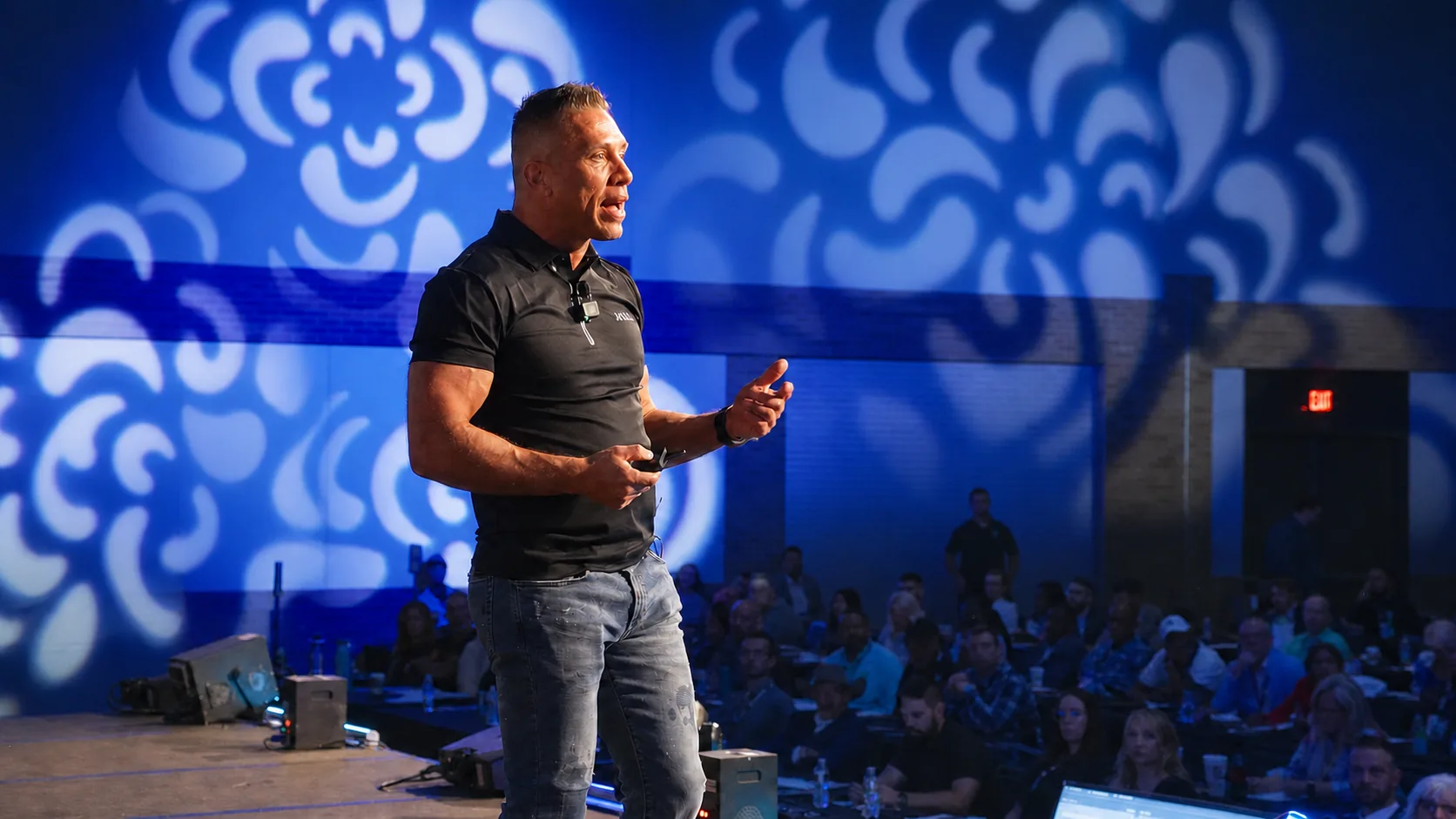David Price speaking on stage to a packed room of insurance agents at a TPG event